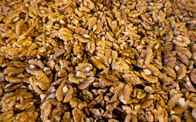 Food ingredients texture. A lot of walnuts without the shell are placed on a table in a food market.