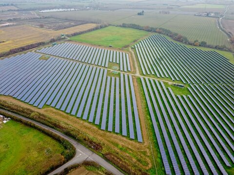 Aerial drone shot. Solar panels farm in a field near Sittingbourne in Kent, England.