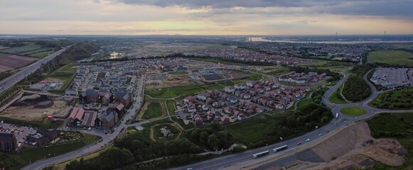 Aerial drone. Ebbsfleet Garden City new builds development with London skyline in the distance. Typical British homes and green gardens. Real estate and buildings concept.