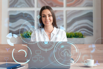 Attractive businesswoman in white shirt at workplace working with laptop to optimize development by implying new technologies in business process. Hi tech hologram over office background