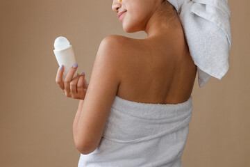 Young woman with deodorant standing in studio - obrazy, fototapety, plakaty