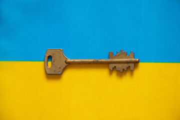 Yellow and blue national flag of Ukraine and the key to the castle apartment in Ukraine as a background, stop the war and peace in Ukraine