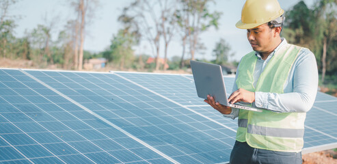 Electrical engineers are using laptops to monitor the operation of the solar rooftop. Renewable energy concepts.