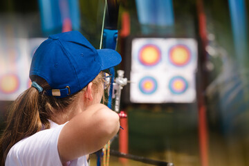 The sportswoman shoots from a bow on the street at a target.