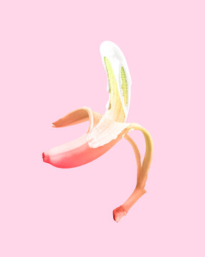 Creative healthy food concept of fruit dipped in white paint that flows down the fruit. Delicious sweet banana on pastel background.