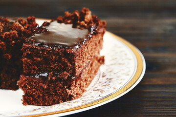 A piece of Chocolate cake on a plate on a wooden background.Slice of Homemade brownie cake.Copy space
