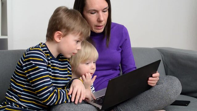 Tired mom teaching kids with laptop and online lessons
