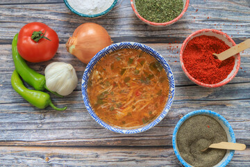 Chicken soup with noodles and vegetables in bowl over rustic wooden background - homemade healthy meal