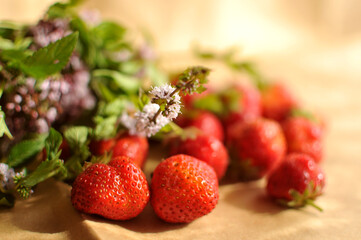 Photo of strawberries with mint on craft paper.