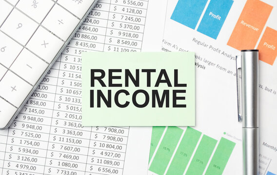 RENTAL INCOME text on sticker with calculator, glasses and magnifier