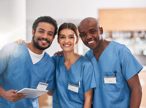 They Are Young But They Are Experienced. Portrait Of A Group Of Cheerful Young Doctors Standing Together With A Digital Tablet Inside Of A Hospital.