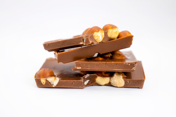 Chocolate pieces with hazelnuts on a white background