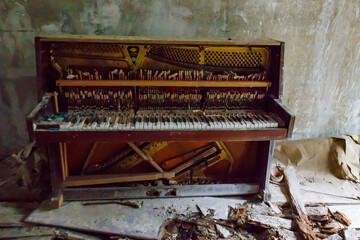 Fototapeta na wymiar Old piano in abandoned apartment in the ghost town Pripyat in Chernobyl Exclusion Zone, Ukraine