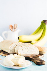 Fresh sliced banana bread and bananas on a plate on the table. Homemade baking. Close-up. Vertical view