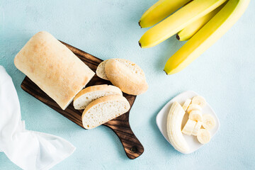 Fresh sliced banana bread and bananas on a plate on the table. Homemade baking. Top view