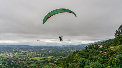 Paraglider flight on the background of the city and mountains.