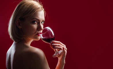 Sensual woman drinks wine. Beautiful girl with glass of red wine. Alcohol, celebration, anniversary.