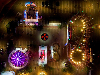 Amusement parkin the night. Roller coaster. Fear. Amusement park lights. Carousel. Drone Image....