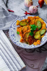 Fried Solanum melongena with Egg in a green dish on the table with garlic, dried chilli
