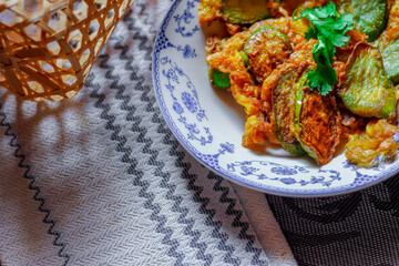 Fried Solanum melongena with Egg in a green dish on the table with garlic, dried chilli