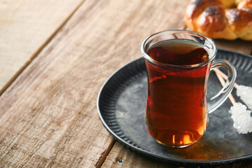 Turkish black tea. Glass cup of turkish black tea and crispy Turkish traditional bagel on old rustick background. Breakfast pastry concept. Traditional turkish brewed hot drink.