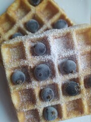 Menu, Belgian, Viennese waffles with blackcurrant berries and powdered sugar (tasty sweet dish, dessert snack), top view.