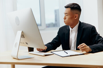 Asian man sitting at a desk in front of a computer Lifestyle