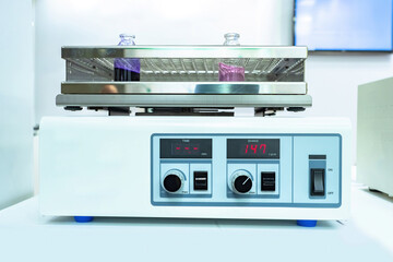 Laboratory apparatus for shake reagents. Medical equipment in the laboratory. Machine for heating reagents in flasks. Two colored test tubes on a laboratory apparatus. Sale of lab equipment