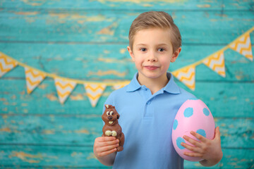 A young boy and decorations for Easter. Studio background.