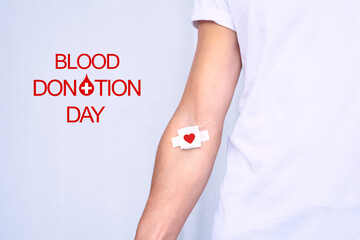 Blood donation day. Blood donor with bandage after giving blood on a white background. Copy space