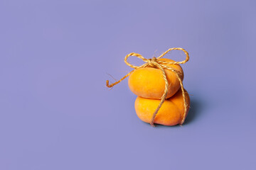 Fresh peach on a purple background tied with a rope twine