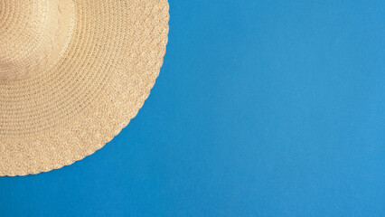 Fototapeta na wymiar Straw hat on a bright blue background. Summer concert. Copy space, flat lay, top view. 