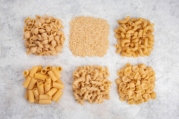Uncooked pasta on white background. Food background. Top view.