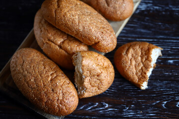 Fresh buns with bran on a wooden surface. Wholemeal bread.