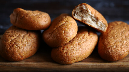Fresh buns with bran on a wooden surface. Wholemeal bread.