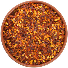 Chili pepper chopped in a brown ceramic bowl isolated on white background. Isolated close-up photo of food close up from above on white background.