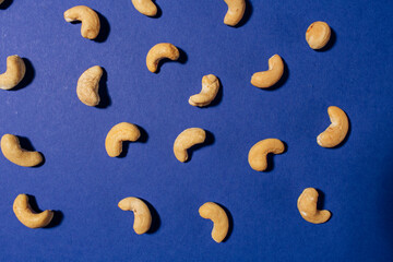 Cashews pattern on a blue background. Nuts creative layout. Top view