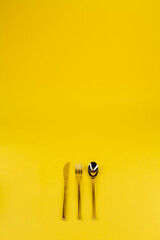 spoon, fork, knife on a yellow background
