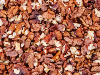 Top view of pile of peeled crushed walnuts as background
