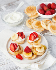Mini pancake cereal with banana, raspberry, strawberry, honey, yogurt for breakfast. Mini pancake cereal is new trend.