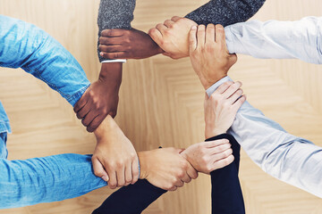 Keep your links strong. Cropped shot of a group of businesspeople linking their arms in solidarity.