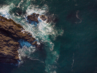 Aerial view. Seascape. Clear turquoise ocean water with white foamy waves and rocky shore. There are no people in the photo. There is free space to insert. Tourism, travel. Postcard, banner.