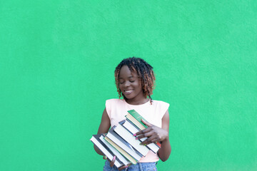 Smiling African-American woman on a green background. Copy space. Back to school