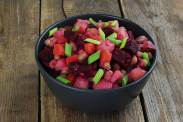 Vinaigrette traditional russian salad with boiled vegetables on wooden background close up