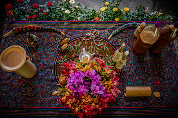 Sao Paulo, SP, Brazil - April 26 2022: Altar for ceremony with colorful flowers, shipibo fabric, kuripes for snuff application and bottles with Ayawasca details - obrazy, fototapety, plakaty