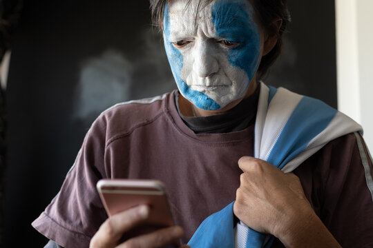 closeup of soccer fan painting the face of argentina celebrating
