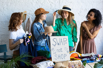 Young women at swap home party - clothes, shoes, bags, jewellery exchange between friends. Zero waste shopping, eco friendly concept, sustainable lifestyle. College life - obrazy, fototapety, plakaty