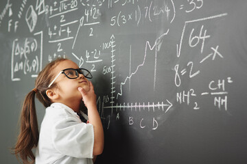 Shes way to clever for her age. Shot of an academically gifted young girl solving a math equation.