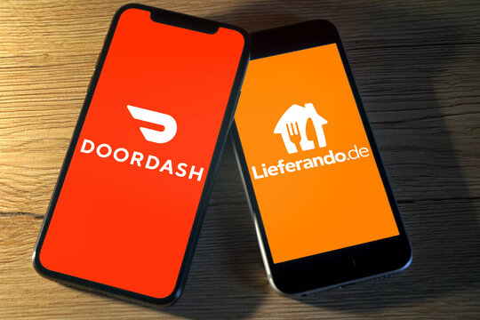 Logos der  Essenslieferdienste Doordash und Lieferando.de werden auf nebeneinanderliegenden Smartphones angezeigt, Gastronomie, Restaurants, Essen, Ernährung, 2022