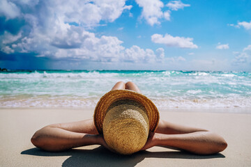Young Woman in Hat Lying on Sandy Beach by the Sea